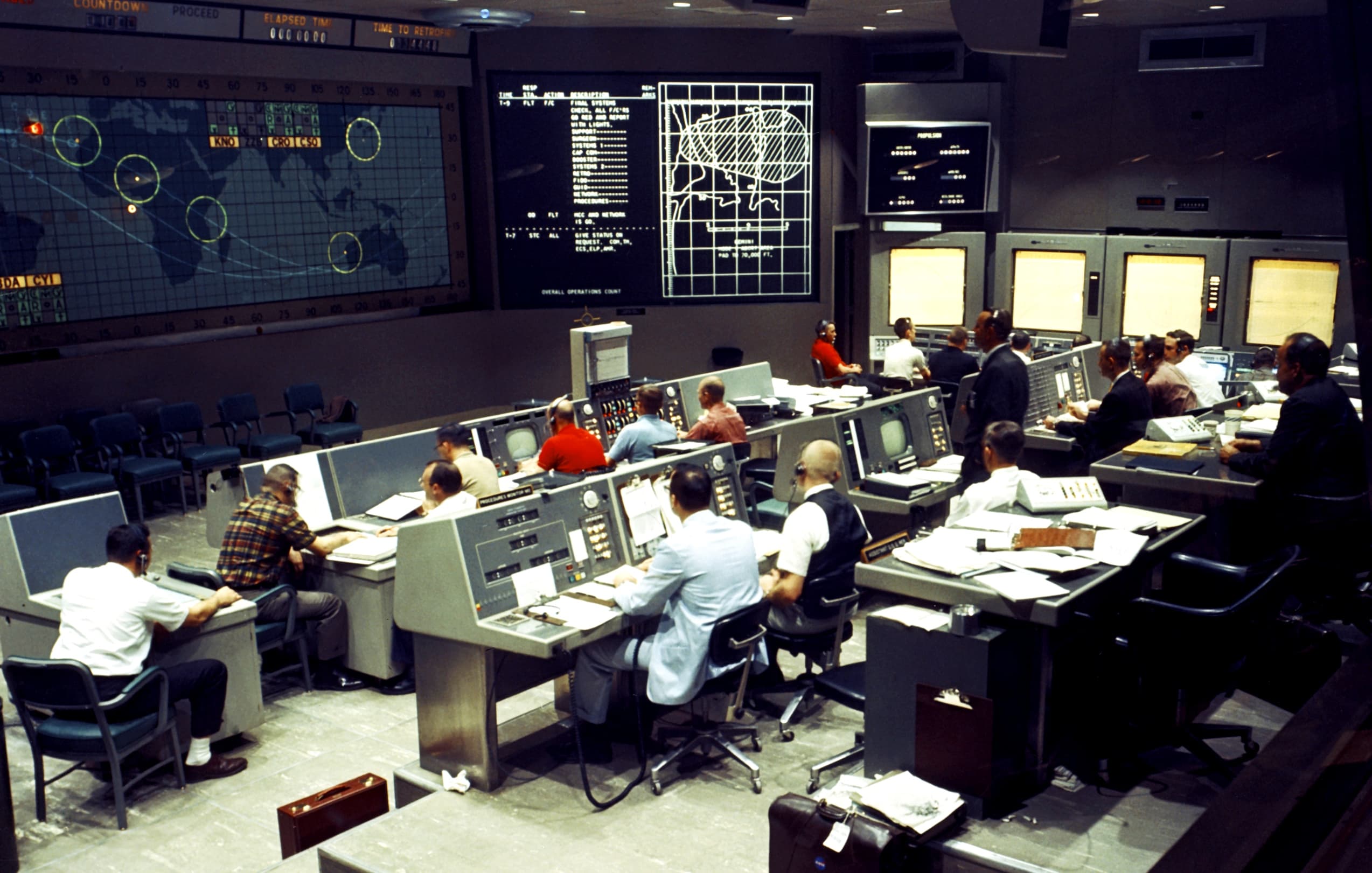 Apollo era Mission Control Center during the Gemini I mission, an orbital test of the Titan-II launch vehicle in April 1964: dozens of human operators, analog consoles, and live telemetry. A system that only worked because people were watching. The stakes were (much) higher than software sales, sure. But the job description? Pretty familiar: make it work.